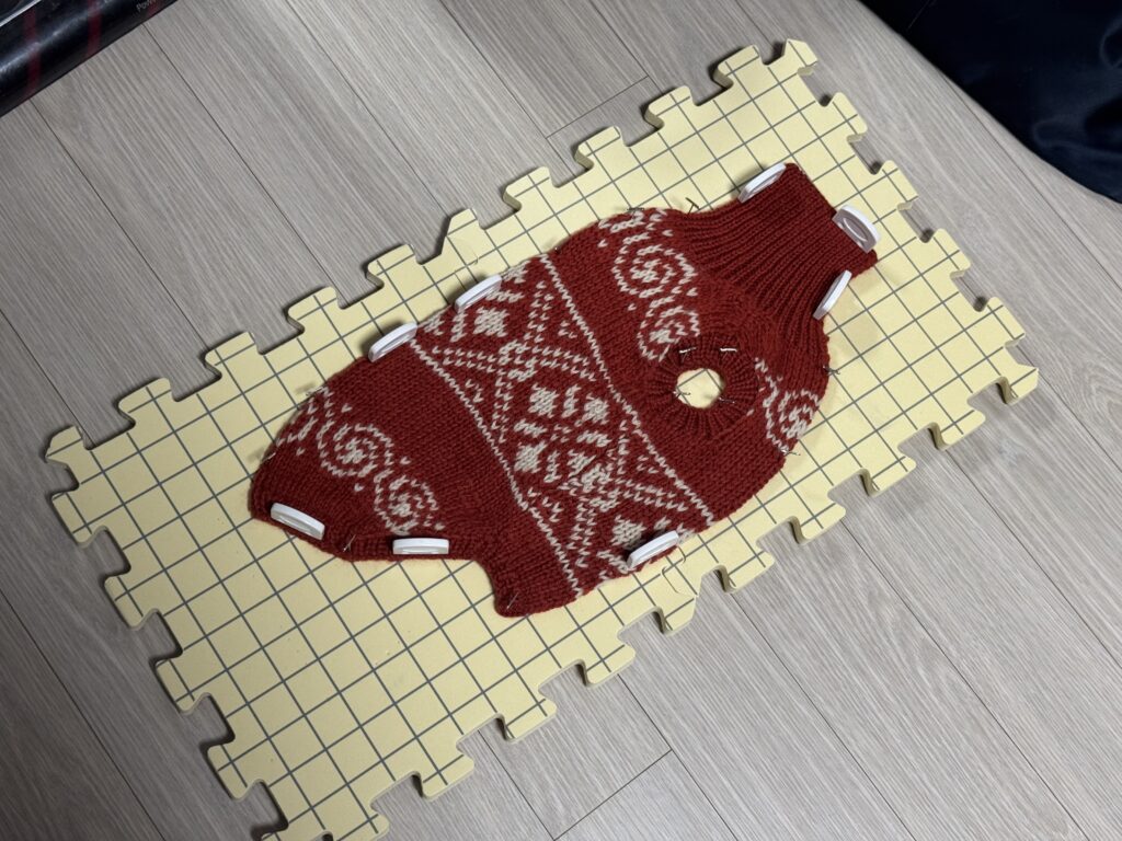 강아지 코위찬 니트를 세탁 후 블로킹 보드에 고정해 형태를 잡고 있는 모습