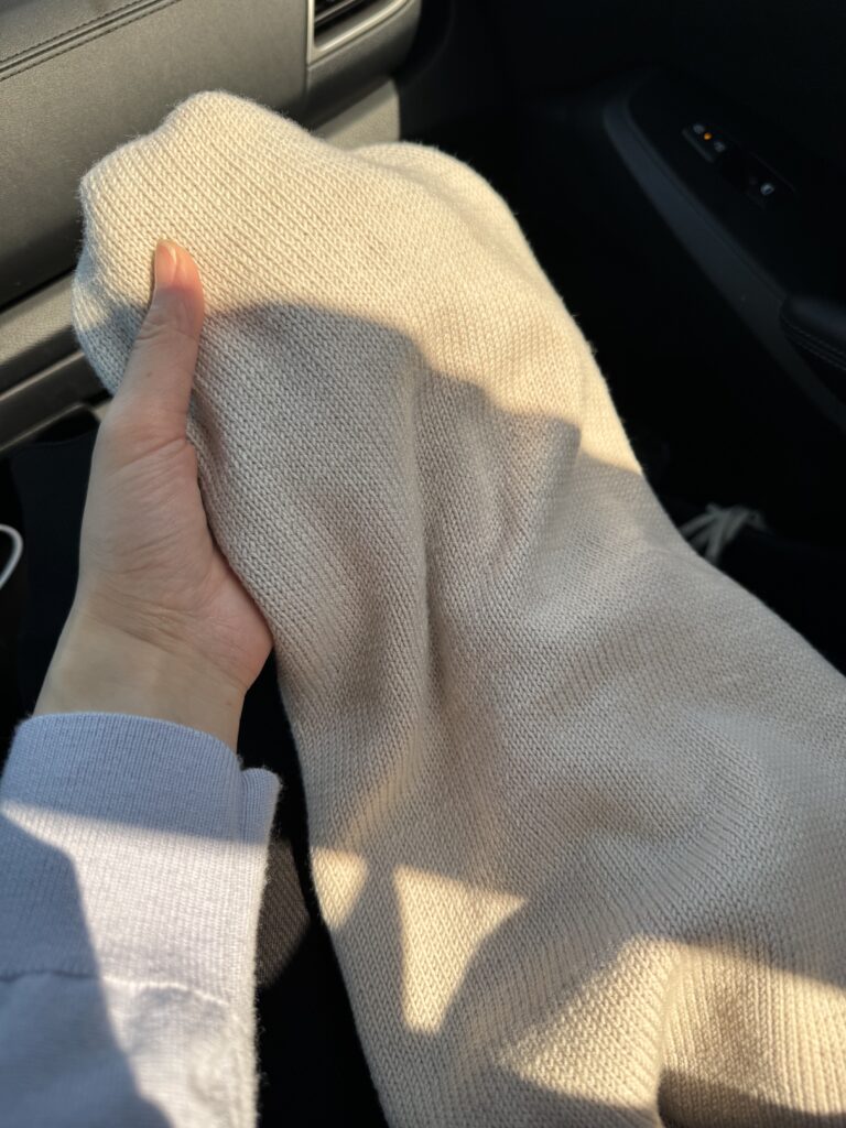 햇빛 아래에서 촬영한 오트밀 컬러 새틴 메리노 울 메리야스 목도리